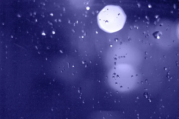 Krople deszczu z efektem bokeh w nocnym mieście. Krople deszczu na okno z abstrakcyjnymi światłami — Zdjęcie stockowe
