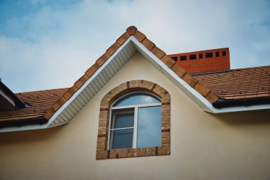 Tavan arası penceresi. Tavan arası pencereli modern dağ evi çatısı. Evin çatısındaki pencere.