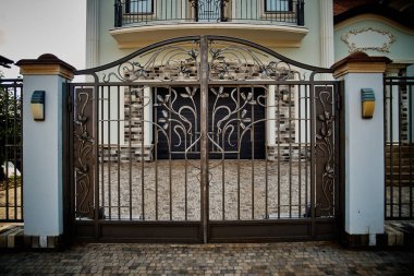 Garaj kapısı. Garajın sonunda mavi kapılı çift katlı bir garaj..