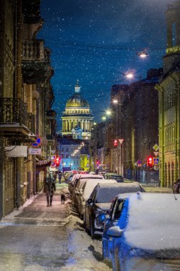 St. Petersburg, Russia - 25 DEC 2021 Bolshaya Podyachnaya Street, St. Isaac's Cathedral and falling snow in the night city