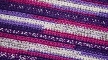 Purple-pink striped crochet pattern background, slow clockwise rotation
