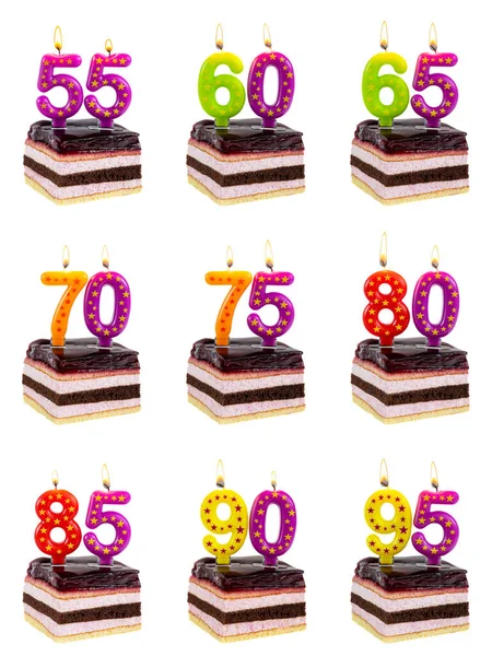 Set of appetizing striped birthday cakes with burning candles in the form of numbers - 55, 60, 65, 70, 75, 80, 85, 90, 95, anniversary concept