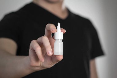 Bir adam burnu akan birine sprey sıkar. Kapat..