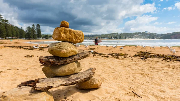 Pedras Empilhadas Praia Com Surfista Andando Segundo Plano Ilustrando Estilo — Fotografia de Stock