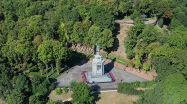 Büyük Prens Vladimir anıtının üzerinde güzel bir sabah uçuşu. Yeşil yapraklı ağaçlar. İnsanlar yürür, aceleyle işe giderler. Yazın güzel bir park.