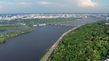 Ukrayna 'nın başkenti Kiev üzerinden güzel bir uçuş. Park ve ağaç yeşil yapraklarla taçlandırılıyor. Birçok ev, köprü ve Dinyeper nehri.