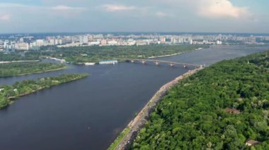 Ukrayna 'nın başkenti Kiev üzerinden güzel bir uçuş. Park ve ağaç yeşil yapraklarla taçlandırılıyor. Birçok ev, köprü ve Dinyeper nehri.