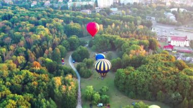 Parkın manzarası güzel, orman yeşilliklerle kaplı. Sabah nehri sisli. Arka planda küçük evler. Balon uçuşa hazırlanıyor..