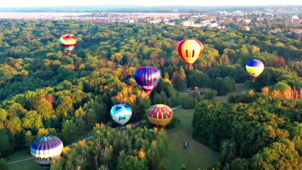 美丽的阳光照亮了飞越公园的气球 以城市景观为背景 美丽的早晨气球飞行 森林的俯瞰 — 图库视频影像