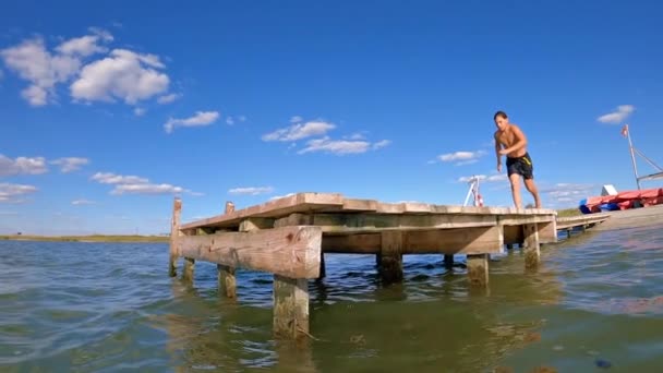 Αγόρι Τρέχει Και Πηδάει Στο Νερό Στη Λίμνη Στο Ποτάμι — Αρχείο Βίντεο