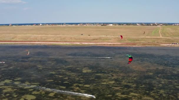 人们在海上冲浪 风带着运动员沿着海浪前进 五颜六色的降落伞从上面看 从四合院到小猫冲浪者 — 图库视频影像