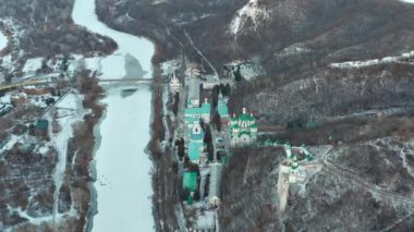 Kutsal Dormition Svyatogorsk Lavra üzerinde kış uçuşu. Üst katta bir sürü kilise var. Yukarıdan gelen Ortodoks manastırı. Nehir buzla kaplı. Karda kış manzarası.