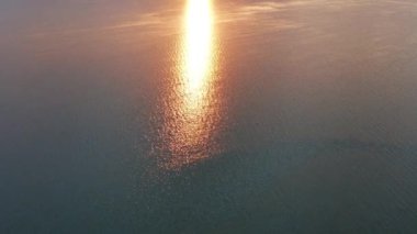Güzel deniz batımı. Gün batımında deniz üzerinde Quadcopter uçuşu. Güneş ufukta saklanıyor. Turuncu, kırmızı güneş deniz yüzeyine yansıyor..