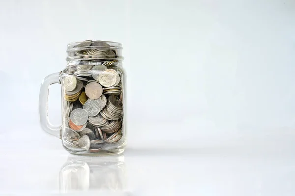 经典玻璃瓶中关于白底储蓄和投资概念的硬币 — 图库照片