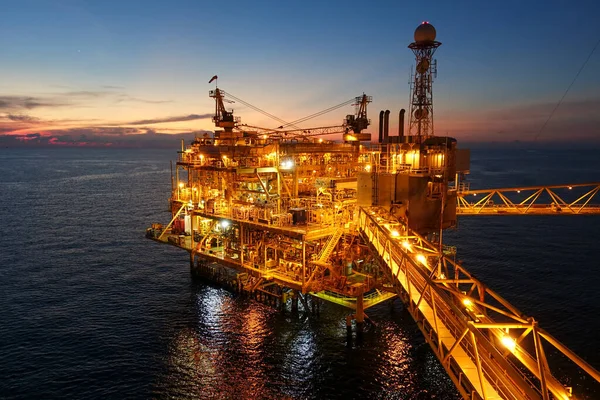 Wolrd kavramının güç enerjisi için gece vakti köprüyle birlikte petrol ve gaz çıkarma platformu.