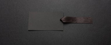 Kara Cuma indirim konsepti. Siyah fiyat etiketi boş, saten kurdeleli maket siyah arkaplan, kopyalama alanı, pankart