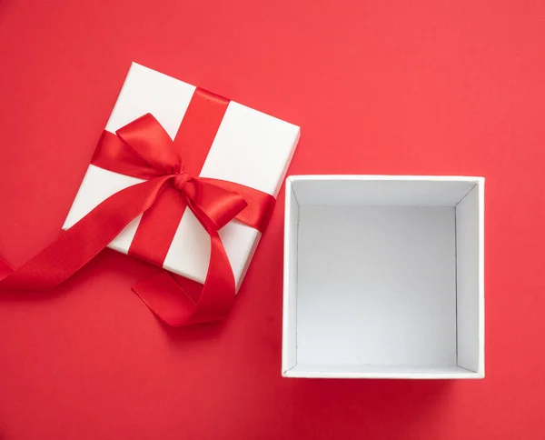 圣诞礼品盒白色 红丝带蝴蝶结 红色背景 情人节惊喜 新年礼物 缎子卷曲装饰 顶视图 复制空间 贺卡模板 — 图库照片