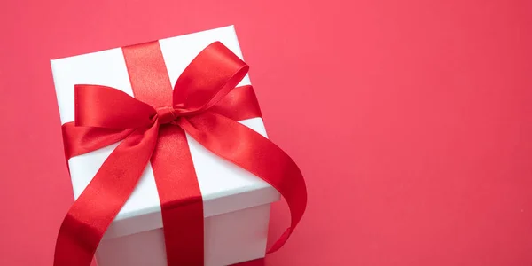 圣诞白色礼品盒 彩带红色背景 情人节惊喜 新年礼物 缎子卷曲装饰 复制空间 贺卡模板 — 图库照片