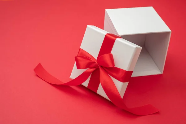圣诞礼品盒白色 红色丝带蝴蝶结 红色背景 情人节惊喜 新年礼物 缎子卷曲装饰 复制空间 贺卡模板 — 图库照片