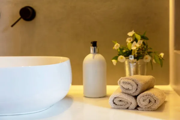 浴室的毛巾卷起 肥皂喷雾器和白盆放在桌子上 现代浴室内部细节 — 图库照片