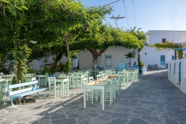 Yunanistan, Folegandros adası. Geleneksel açık kafe bar ve taverna. Chora Meydanı 'nda mavi boş masa ve sandalyeler. Kiklad. Yaz tatilleri