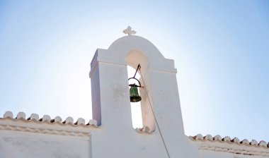 Yunan Ortodoks Hıristiyan Kilisesi kiremit çatısında eski çanı olan çan kulesi. Kythnos Adası 'ndaki Whitewashed Şapeli. Chora Köyü Cyclades dini varış noktası Yunanistan. Görüntü altında.
