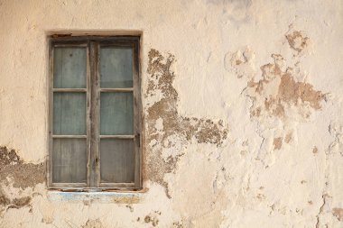 Derelict ev konsepti. Pencere, içi ahşap kaplamalarla kaplı, yıpranmış, yıpranmış, boş, pembe duvarlı arka plan. Terk edilmiş eski püskü, yıpranmış dış bina. Boşluk, boşluğu kopyala.