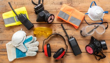 Sanayi ve şantiye için iş sağlığı ve güvenliği. Kişisel işçi koruma donanımı düz yerde yatıyordu. Ahşap arka planda koruma ekipmanları,