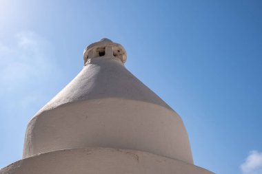 Yunan adası, Yunanistan 'da, binanın çatısındaki beyaz baca. Bir binanın çatısında baca bacası inşaatı var. Mavi gökyüzü arkaplanı.