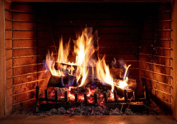 燃点柴火 木柴上的篝火 砖头背景 圣诞节时舒适的房间里 寒假和温暖的家 — 图库照片