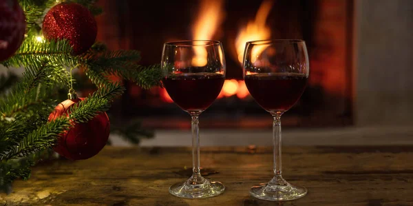 Natale Due Bicchieri Vino Rosso Tavolo Legno Bruciante Sfondo Camino — Foto Stock