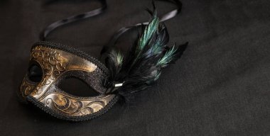 Koyu gri arka planda siyah tüyleri olan Venedik karnavalı maskesi, kopyalama alanı, afiş. Mardi Gras etkinliği maskesi, geleneksel festival maskeli balosu.
