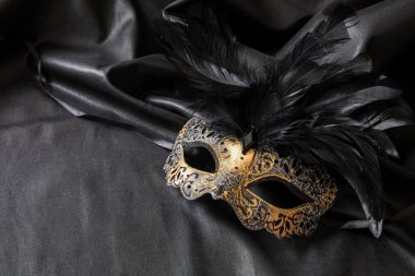 Koyu gri arka planda siyah tüylü Venedik karnavalı altın maskesi, kopyalama alanı, şablon. Geleneksel festival kadın kıyafeti, Mardi Gras etkinliği maskeli balosu