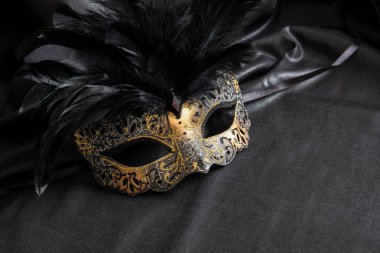Karnaval partisi. Koyu gri arka planda siyah tüylü Venedik altın maskesi, kopyalama alanı, şablon. Geleneksel festival kadın kılığı, maskeli balo