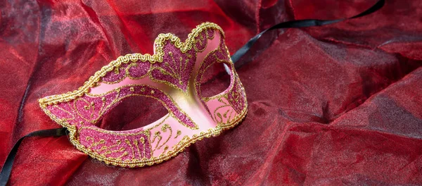 嘉年华威尼斯人面具粉红的颜色 闪烁着红色的纺织品背景 传统节日女装 化装舞会 — 图库照片