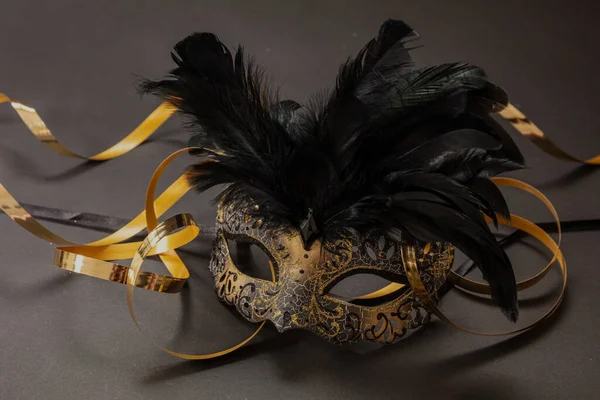 Carnaval Venetiaans Masker Met Zwarte Veren Gouden Slingers Donkergrijze Achtergrond — Stockfoto