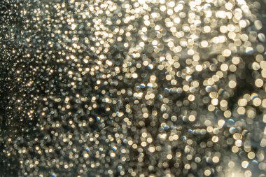 Işıklar siyah arkaplanda yanar. Soyut desen, gümüş beyazı parıltı, parlak bulanık arkaplan. Noel süslemesi