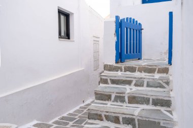 Cyclades, Yunanistan. Ios, Nios Adası, Chora. Beyazlatılmış binalar, taş döşeli merdivenler ve mavi ahşap çit girişi açık, yaz tatilleri