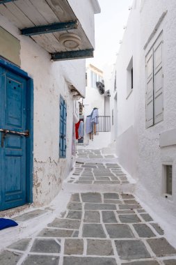 Cyclades, Yunanistan. Ios, Nios Adası, Chora. Boş asfalt sokakta alışveriş yapıyor. Beyazlatılmış binalar, dar kaldırım taşı sokakları, geleneksel mimari. Yaz tatili
