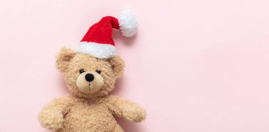 Noel hediyesi. Oyuncak ayı pembe arka planda Noel Baba şapkası takıyor, afiş, fotokopi odası. Çocuklar bayram hediyeleri, oyuncaklar ve peluş hayvanlar. Tatil tebrik kartı..