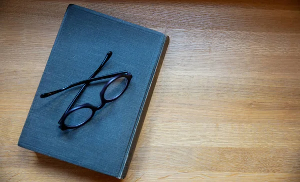 Hardcover Book Table Closed Old Black Notebook Eyeglasses Wooden Background — Fotografia de Stock