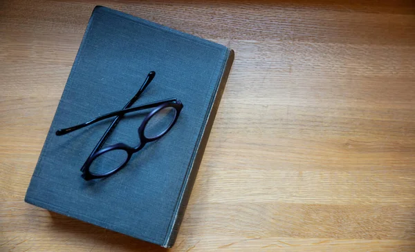 Livro Capa Dura Uma Mesa Caderno Preto Velho Fechado Óculos — Fotografia de Stock