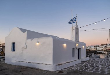 Paros Adası 'ndaki Agios Nikolaos Rum Ortodoks Kilisesi. Limanda çan kulesiyle bembeyaz yıkanmış geleneksel kilise, Naoussa Köyü Cyclades Yunanistan 'da denizcilerin azizi Aziz Nicholas.