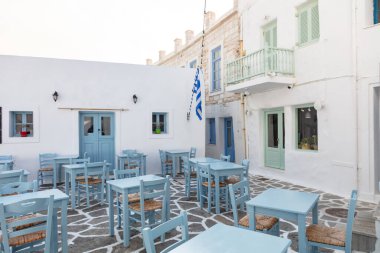 Greece, Paros island Naousa old port. Outdoor cafe restaurant empty tables and chairs at the seaside