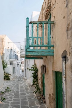 Paros island, Greece. Whitewashed building, empty narrow cobblestone street and closed doors and windows at Naousa old town