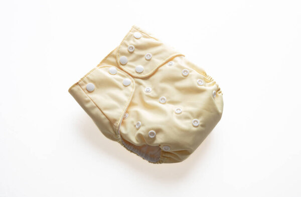 Baby diaper  isolated on white background. Reusable cloth nappy, closed, yellow color. Eco friendly, sustainable lifestyle