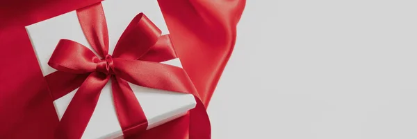 情人节礼物 圣诞礼物 卷曲装饰 白色盒子的头顶 红色缎带和缎子织物上的蝴蝶结包裹 空白的白色空间 — 图库照片