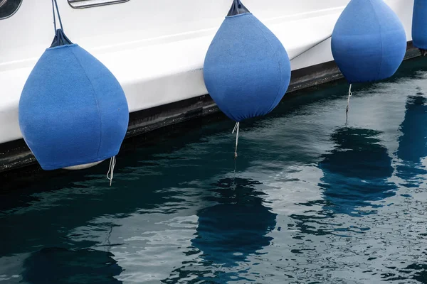 游艇挡泥板 豪华游艇停泊在码头的细节 蓝色橡胶保险杠 反映在海水上 — 图库照片
