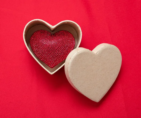 情人节带着爱的象征 一颗红宝石心形的宝石在敞开的心形礼盒里 红色的背景 2月14日的爱情庆典 间接费用视图 — 图库照片