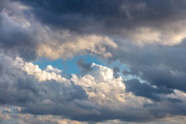 Mavi arka planda gün doğumu renkli bulut. Kümülüs bulutlu beyaz gri renk ve turuncu ton. Gün batımı ışığı bulutlu gökyüzünü renklendirir. Alacakaranlık, şafak vakti